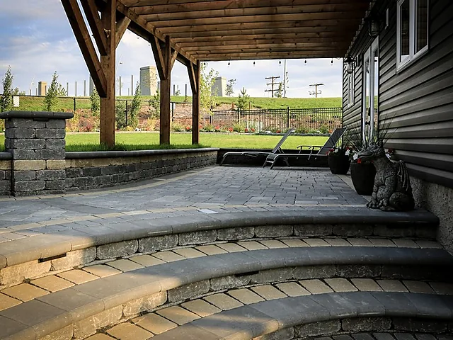 Curved paver stairs and patio under a covered pergola